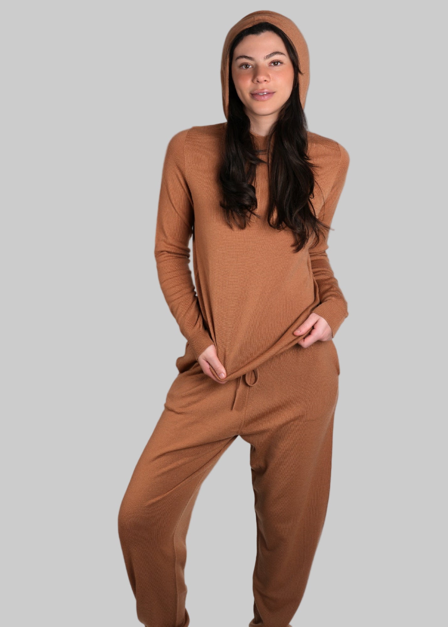 Woman wearing a brown onesie against a gray background