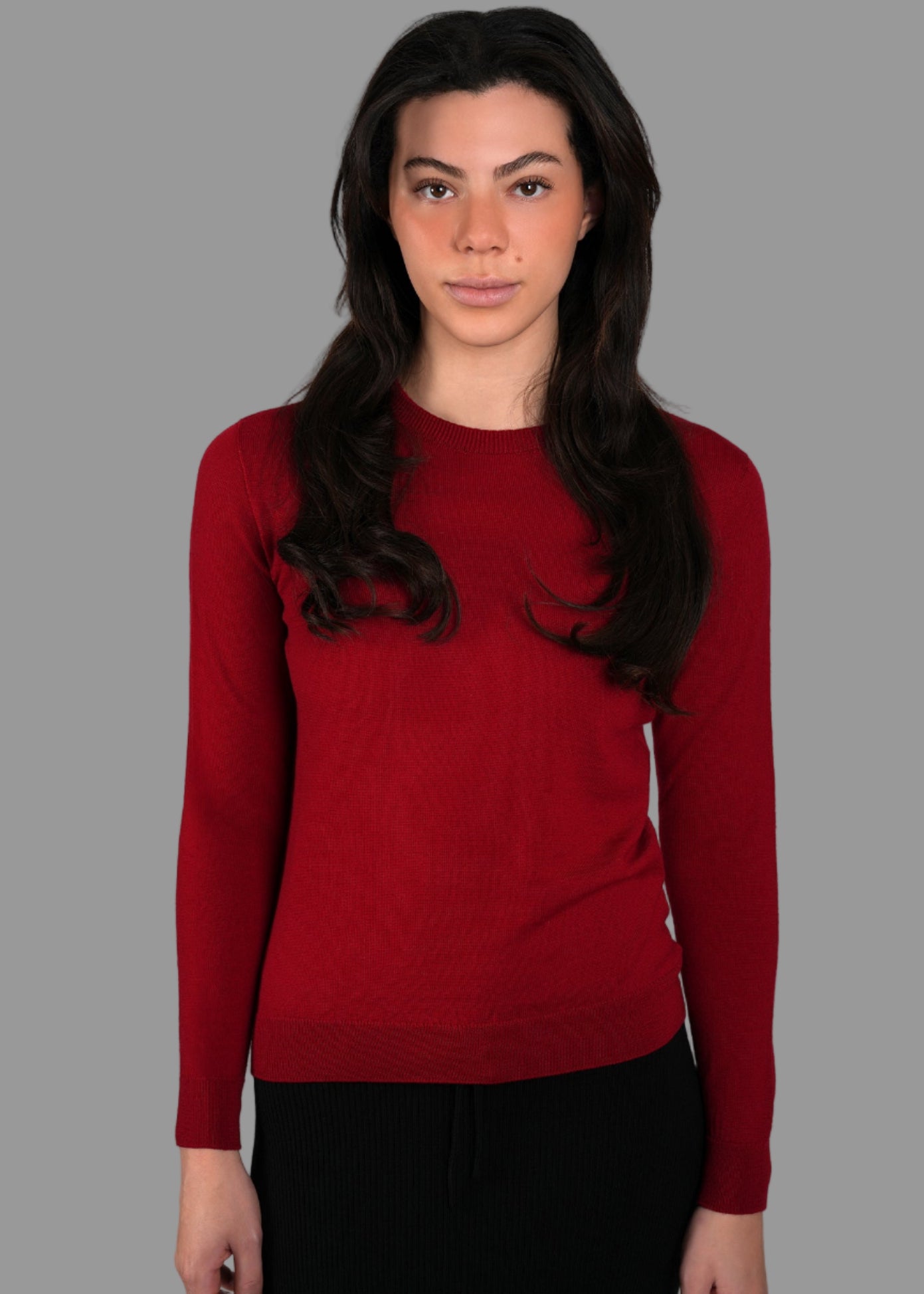 Woman wearing a red sweater against a gray background